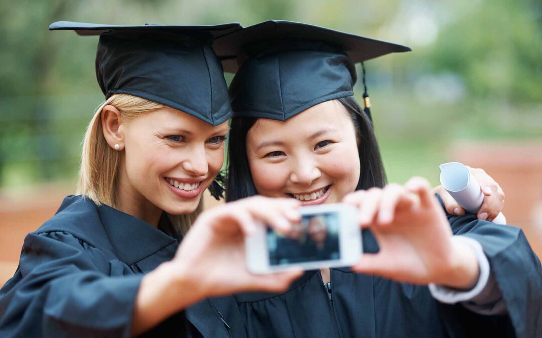 2 young high school students happy after graduating. Showing college admissions secrets can help you get into your college!